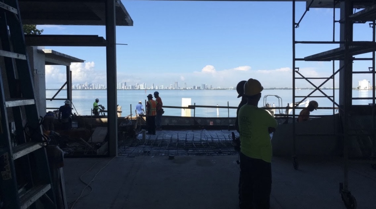Construction crew at a waterfront project with scaffolding and structural work